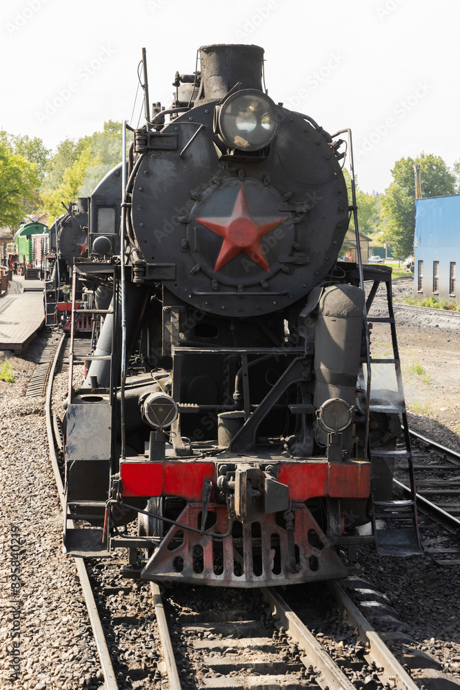Naklejka premium Black steam locomotive with red star from USSR times close up