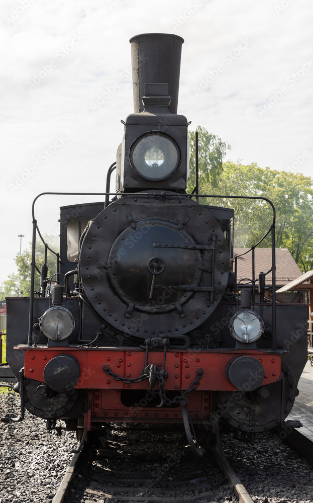 Naklejka premium Vintage black steam locomotive, vertical photo, front view