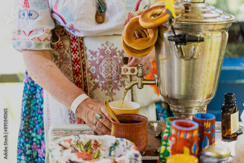 Copper samovar with white teapots and cup of herbal tea photo