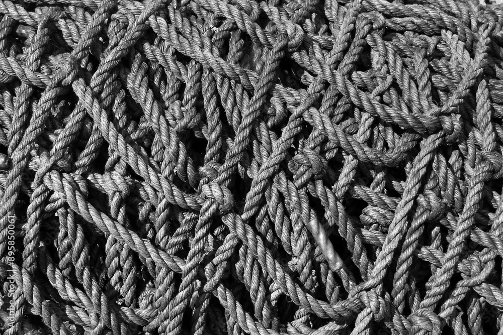 Close-up of a tangled pile of black ropes, showcasing their intricate braided texture and vibrant color Close-up of a tangled pile of black ropes, showcasing their intricate braided texture and vibrant color