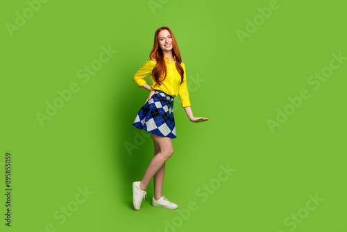 Full body photo of attractive young woman show measure dressed stylish yellow clothes isolated on green color background