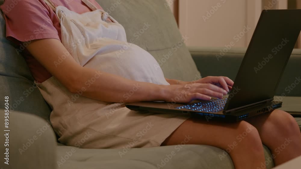 Pregnant woman who is using the keyboard laptop working while on maternity leave. Pregnant woman freelancing on a laptop close-up. Pregnant woman who is using the keyboard laptop working while on maternity leave. Pregnant woman freelancing on a laptop close-up.