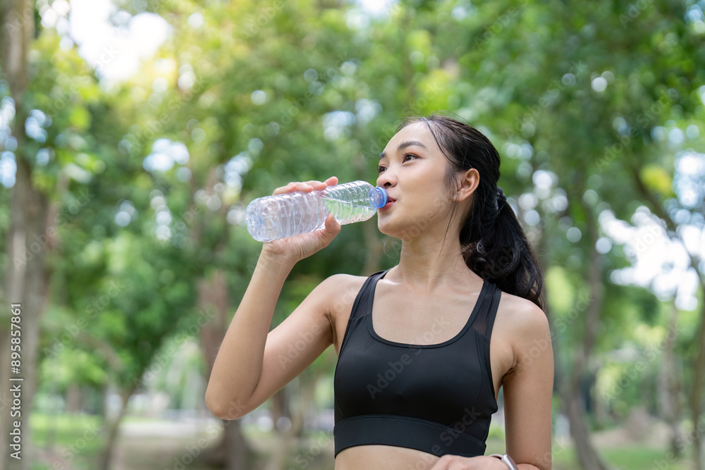 Young Woman Drinking Water During Outdoor Workout in a Park on a Sunny Day Young Woman Drinking Water During Outdoor Workout in a Park on a Sunny Day