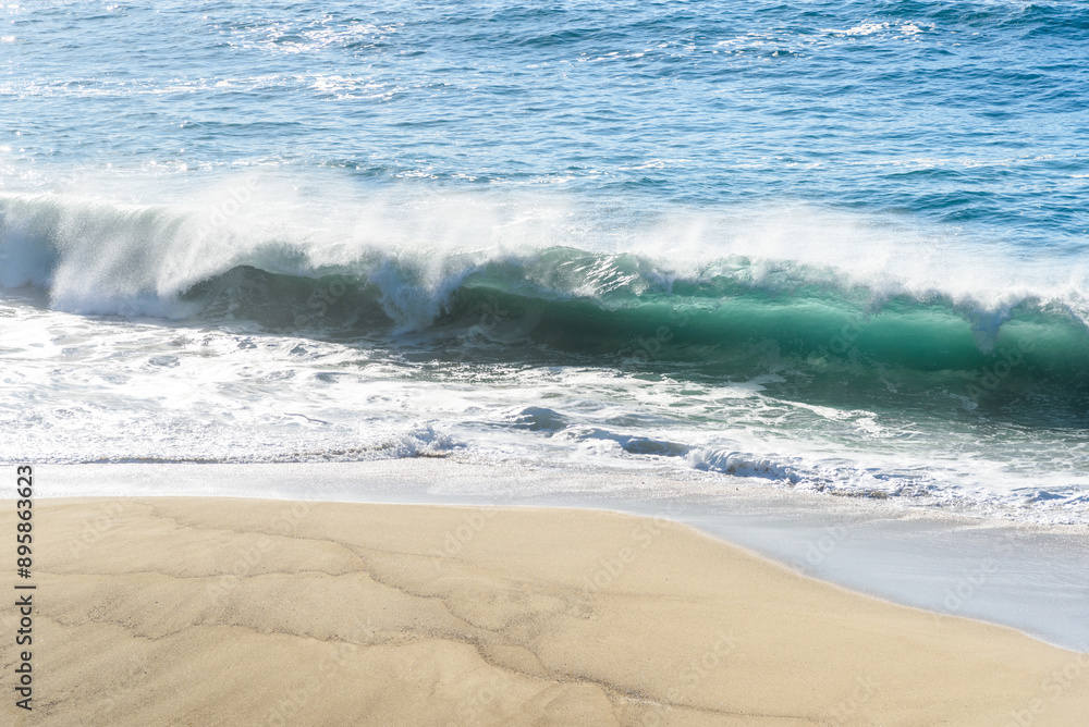 View from above of a huge wave breaking on a sandy beach in California on a sunny day View from above of a huge wave breaking on a sandy beach in California on a sunny day