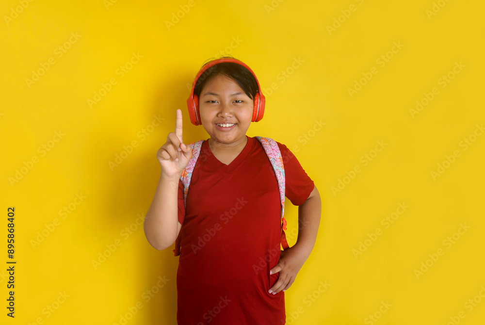 Asian Little Fatty Girl With Headphones And Backpack Pointing Finger With happy Expression Asian Little Fatty Girl With Headphones And Backpack Pointing Finger With happy Expression