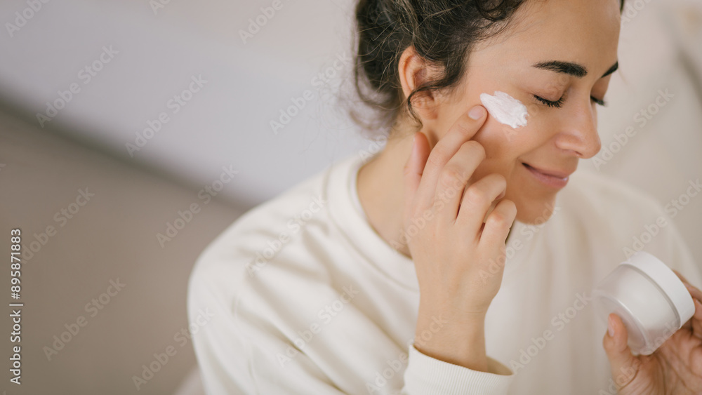 Young woman 30 years old applying face cream on her skin. Young woman 30 years old applying face cream on her skin.