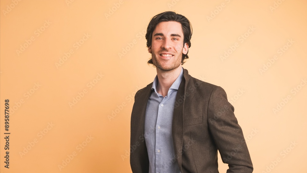 Smiling man in jacket looking at camera in brown studio Smiling man in jacket looking at camera in brown studio