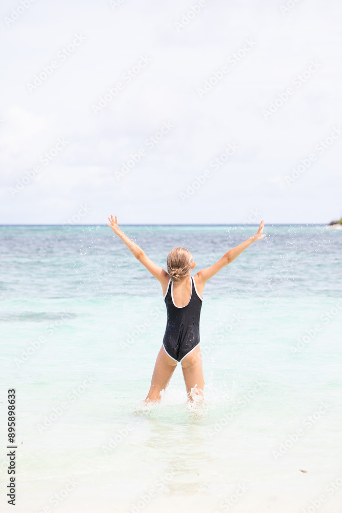 Excited young girl having fun at the beach during summer Excited young girl having fun at the beach during summer