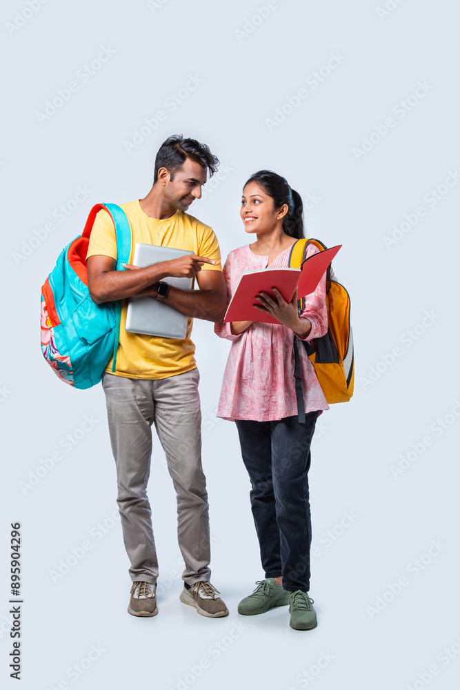 Two Happy Indian College Students with Bags and Laptop, Isolated on White Background Two Happy Indian College Students with Bags and Laptop, Isolated on White Background