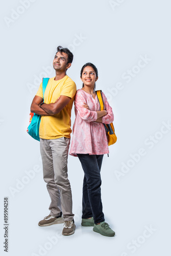 Two Happy Indian College Students with Bags and Laptop, Isolated on White Background
