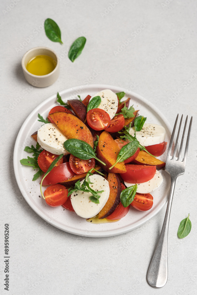 Peaches, tomatoes, mozzarella salad in plate on white background. Caprese italian traditional salad top view Peaches, tomatoes, mozzarella salad in plate on white background. Caprese italian traditional salad top view