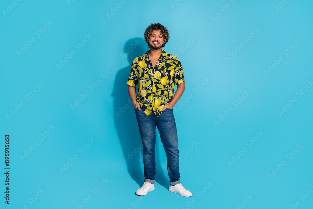 Fototapeta premium Full size photo of handsome cool latin man dressed print shirt jeans standing holding arms in pockets isolated on blue color background