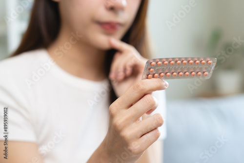 Foto young female holding birth control pills