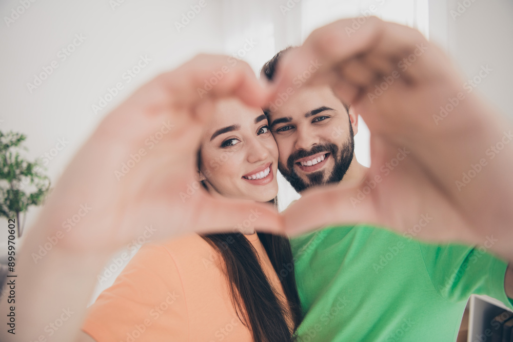 Obraz premium Photo of attractive trendy cheerful show heart gesture married young couple spending free time move new apartment home interior indoors