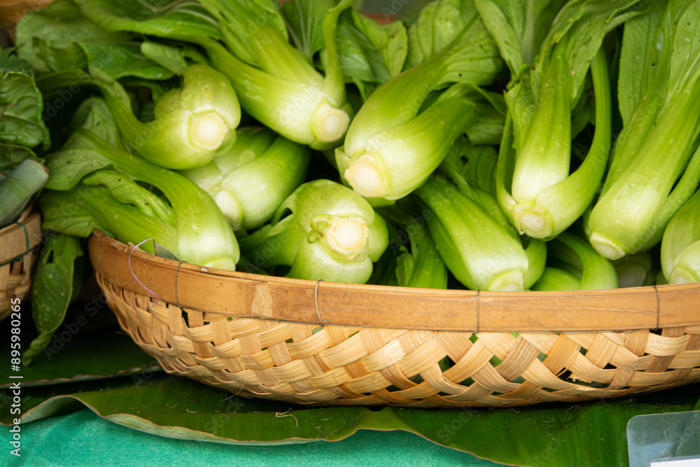 A basket full of green vegetables including broccoli and asparagus. The basket is on a table and the vegetables are fresh and ready to be eaten A basket full of green vegetables including broccoli and asparagus. The basket is on a table and the vegetables are fresh and ready to be eaten