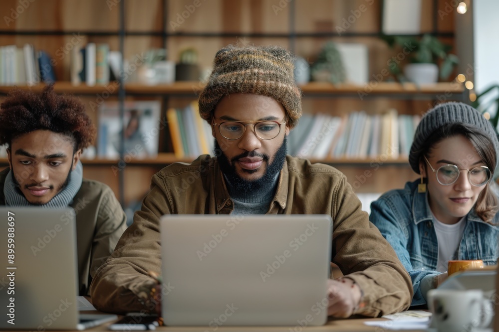 custom made wallpaper toronto digitalA group of three individuals working diligently on their laptops in a cozy library, exuding a warm atmosphere of concentration, collaboration, and productivity.