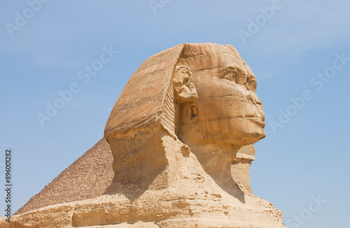Great Sphinx against pyramides and blue sky, Giza, Egypt