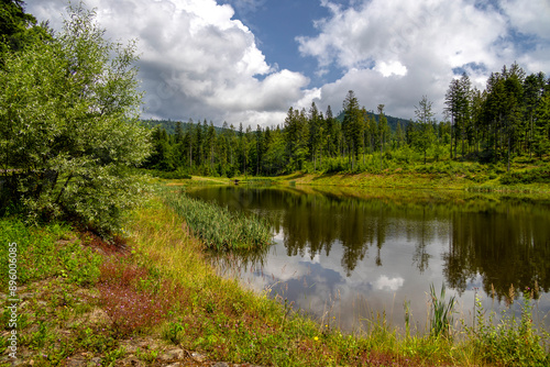 View of the Olza reservoir with reflections in the water on a hot summer day