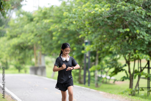 A young woman prepares for her workout, adjusting her fitness gear and setting her smartwatch