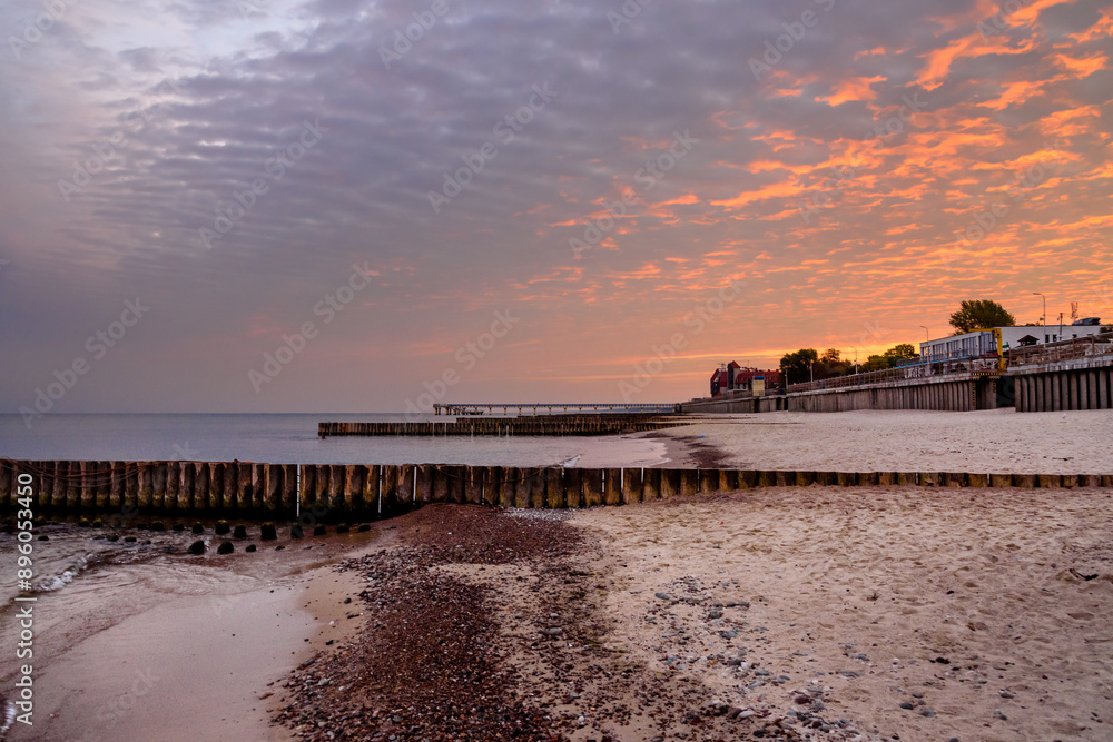 View of sand beach with wooden breakwaters on the Baltic Sea coast on sunrise in Zelenogradsk. Russia