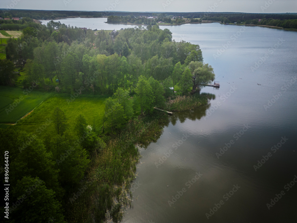 Aerial view of tranquil lake Grojeckie with lush vegetation and serene shoreline, Grojec Maly, Poland.