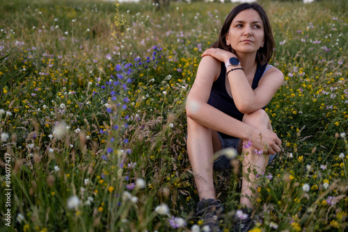 A young dreamy girl is sitting in nature.