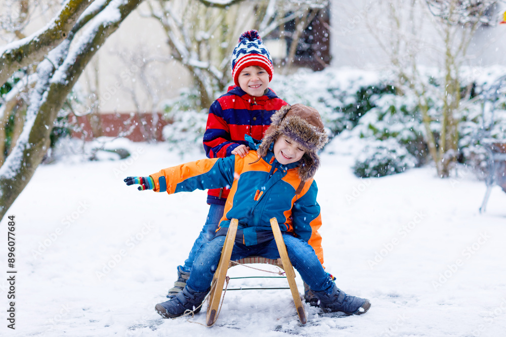 Two kid boys having fun sleigh ride during snowfall. Children sledding on snow. siblings riding a sledge. Twins play outdoors. Friends sled in snowy winter park. Active fun for family vacation Two kid boys having fun sleigh ride during snowfall. Children sledding on snow. siblings riding a sledge. Twins play outdoors. Friends sled in snowy winter park. Active fun for family vacation