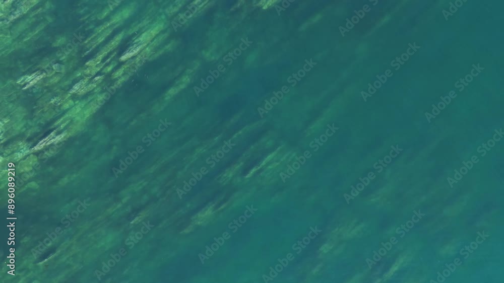 Aerial view in Monteferro, Nigrán, capturing rugged coastal rocks submerged in turquoise waters. The camera starts close to the water, gradually ascending to reveal more of the coastal landscape. Aerial view in Monteferro, Nigrán, capturing rugged coastal rocks submerged in turquoise waters. The camera starts close to the water, gradually ascending to reveal more of the coastal landscape.