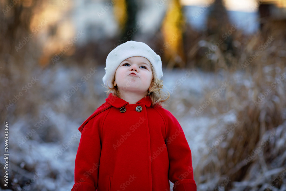 Φωτογραφία Outdoor winter portrait of little cute toddler girl in red coat and white fashion hat barret