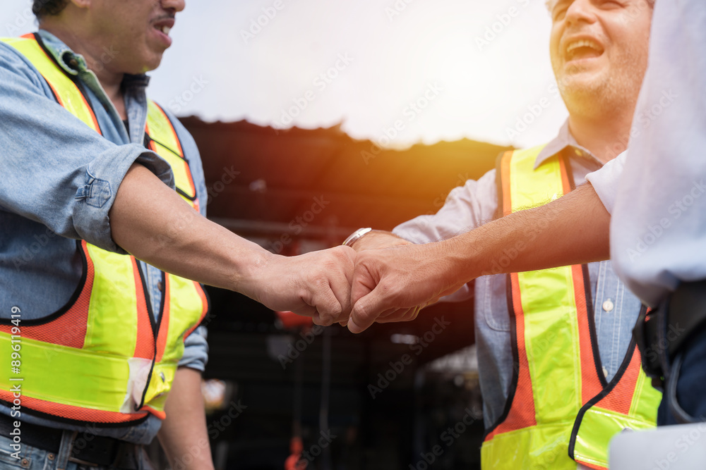 Group of male engineer construction putting their hands together at construction site. Group of male construction builder working at construction site. Unity and teamwork concept Group of male engineer construction putting their hands together at construction site. Group of male construction builder working at construction site. Unity and teamwork concept