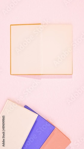 Wallpaper Mural Vertical flat lay arrangement of vintage books on pastel pink background. Stop motion  Torontodigital.ca