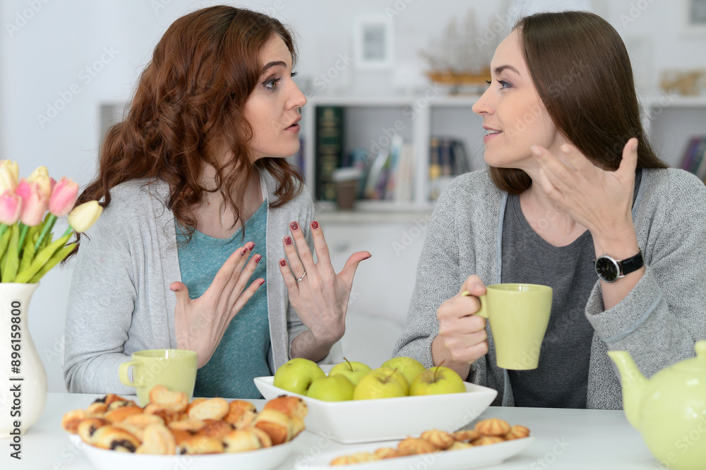 Two best friends eating while sitting at the table together Two best friends eating while sitting at the table together