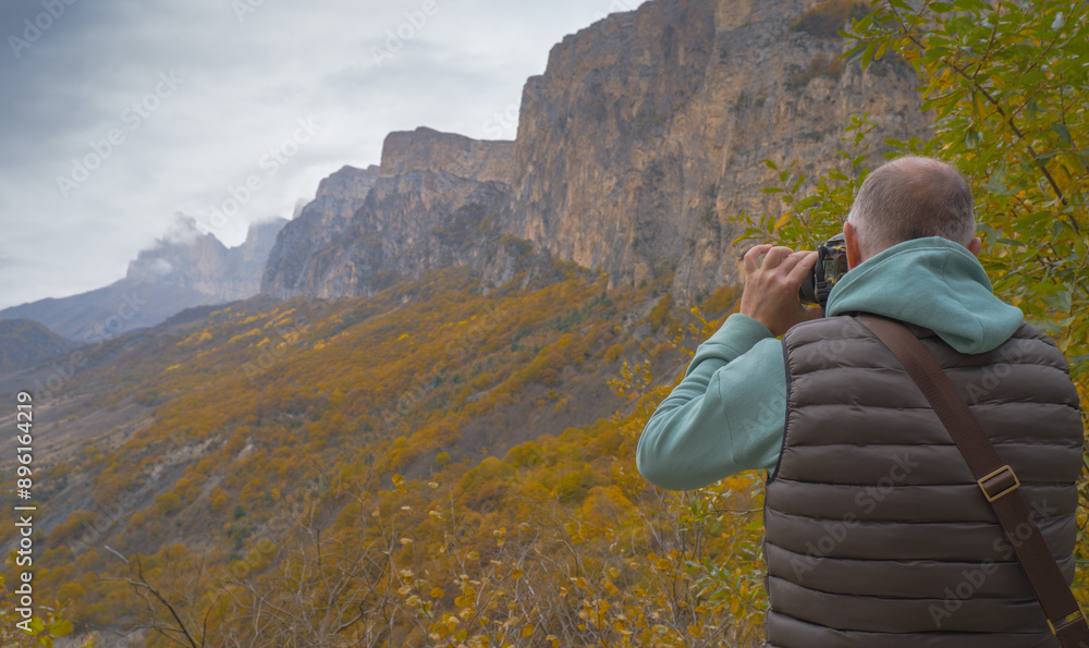Male nature photographer takes pictures in the mountains