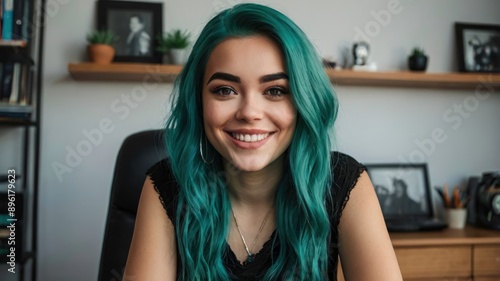 Girl with teal hair  smiling in home office  looking at camera