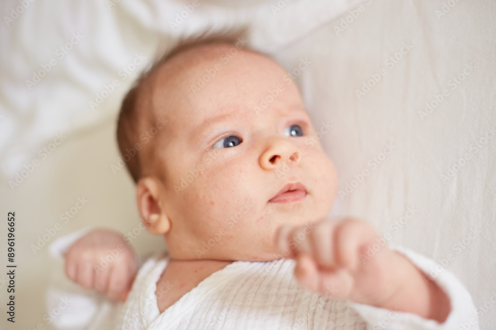 Newborn Baby Boy Lying on White Blanket With Frown Newborn Baby Boy Lying on White Blanket With Frown