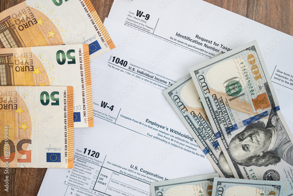 Banknotes of dollar and euro currency placed on different tax forms necessary for taxpayers to report annual income with details in accordance with strict laws on table Banknotes of dollar and euro currency placed on different tax forms necessary for taxpayers to report annual income with details in accordance with strict laws on table