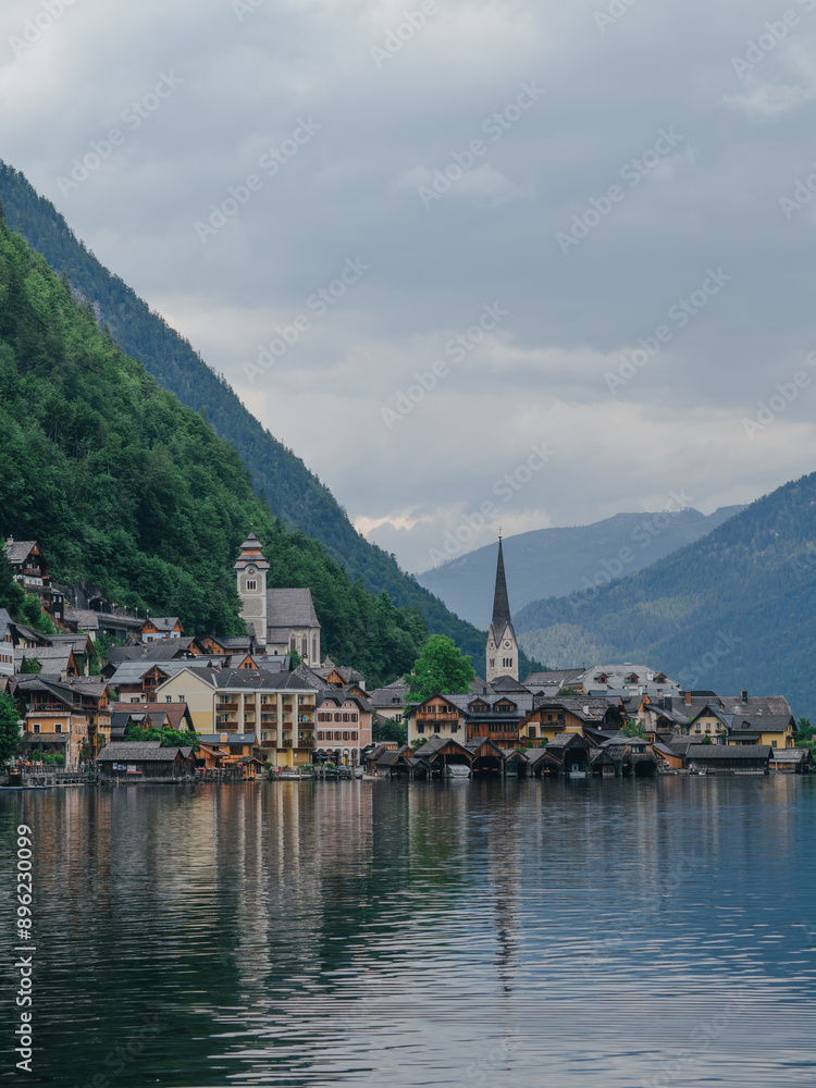 Fototapeta premium Hallstatt village reflecting on tranquil lake during cloudy day