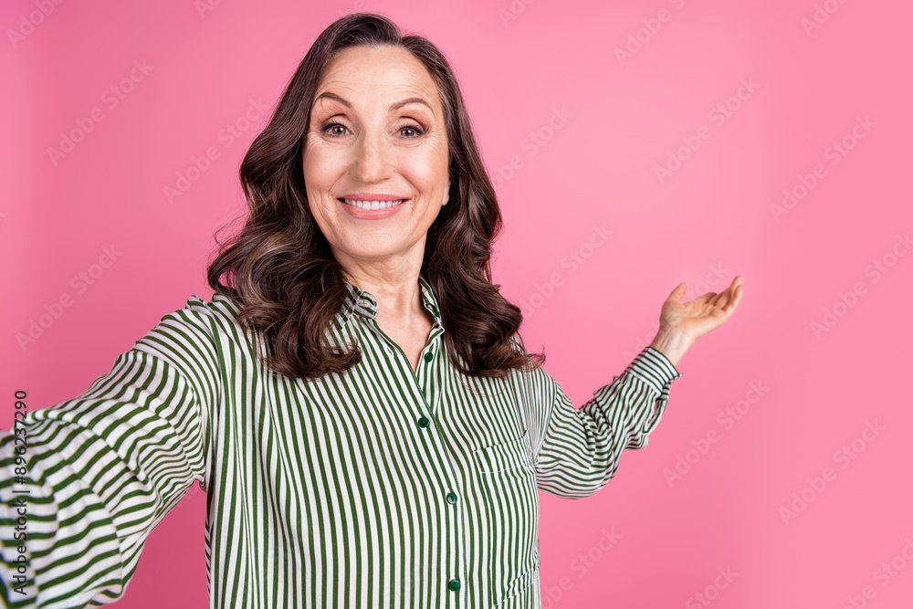 Portrait of pretty aged woman take selfie show empty space wear striped shirt isolated on pink color background Portrait of pretty aged woman take selfie show empty space wear striped shirt isolated on pink color background