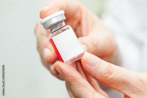 Fotografía Close up of doctor hands while holding a vial of an injectable liquid medicine
