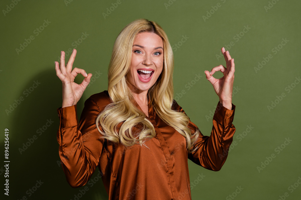 Photo of gorgeous cheerful woman wear silky trendy clothes arm okey sign isolated on khaki color background Photo of gorgeous cheerful woman wear silky trendy clothes arm okey sign isolated on khaki color background