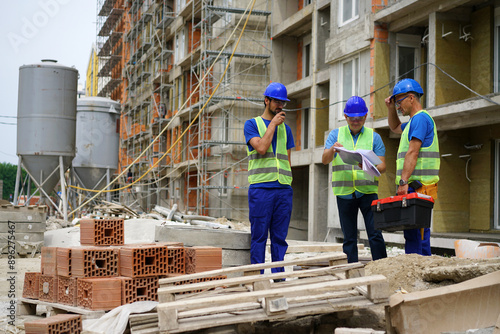 Engineer coworker in protective workwear discussing while working together at construction site