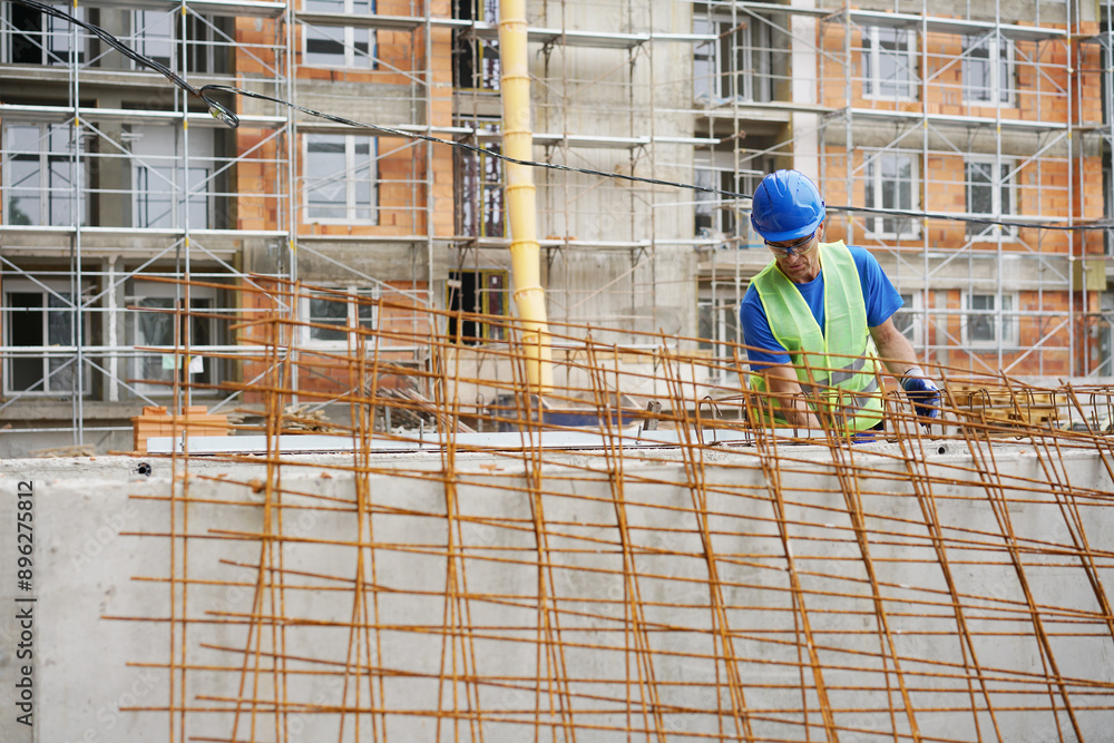 Fototapeta premium Construction worker and reinforced concrete, building at the construction site