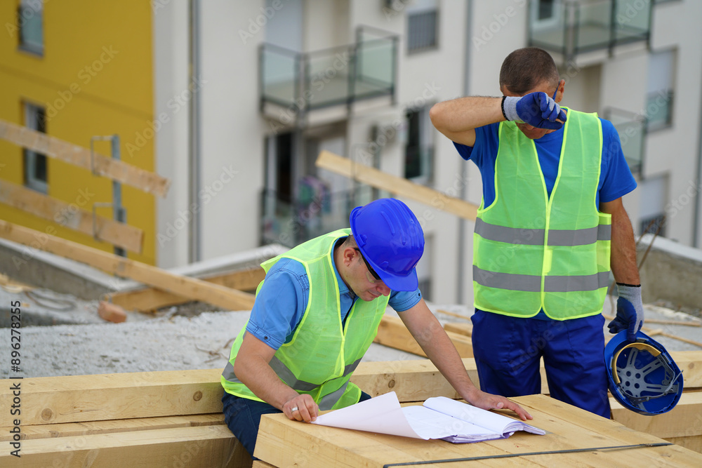 The engineer is discussing with on the roof of the building. The engineer is discussing with on the roof of the building.