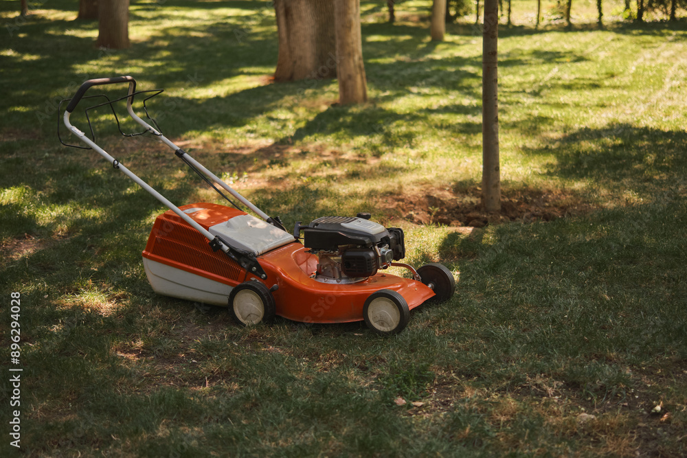 lawnmower on the lawn in the park, the concept of maintaining regular parks and caring for the urban environment lawnmower on the lawn in the park, the concept of maintaining regular parks and caring for the urban environment