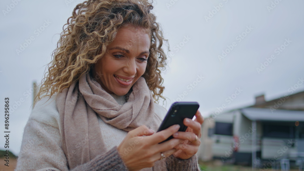 Positive lady messaging mobile phone on cloudy nature close up. Smiling woman Positive lady messaging mobile phone on cloudy nature close up. Smiling woman