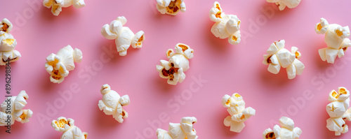 Popcorn scattered on a pink background, top