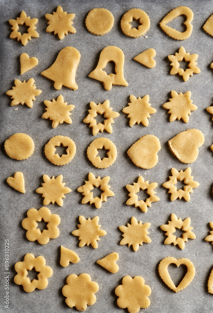 Shapes made of pastry dough on a sheet of baking paper - preparation of Linzer Christmas cookies Shapes made of pastry dough on a sheet of baking paper - preparation of Linzer Christmas cookies