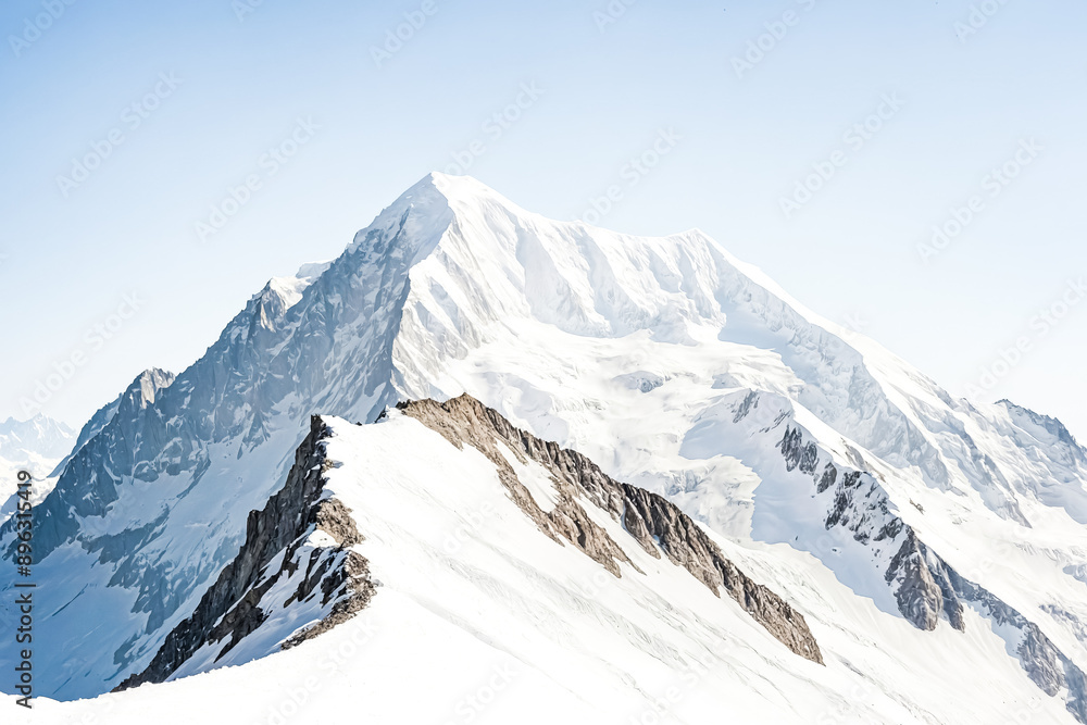 Obraz premium Majestic Snow-Capped Mountain Peak Against a Clear Blue Sky