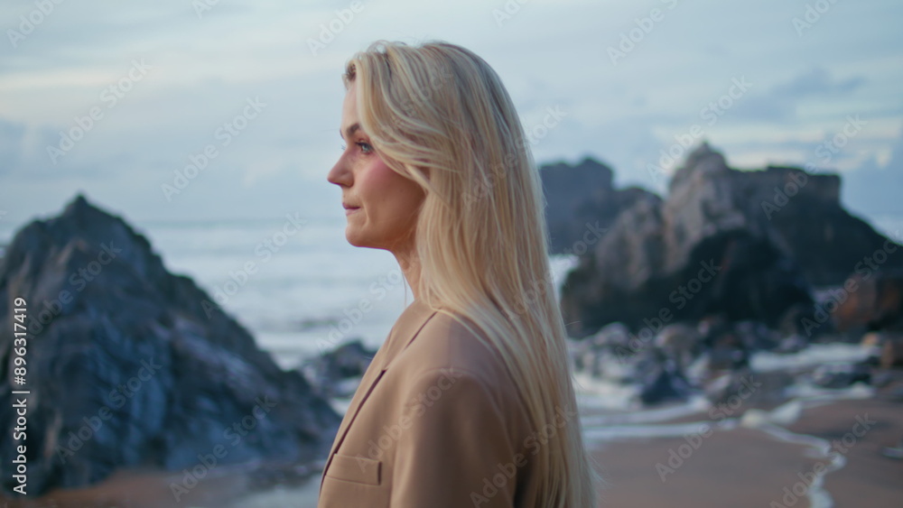 Fashion model posing sunset beach at cloudy sky. Closeup sexy blonde in suit Fashion model posing sunset beach at cloudy sky. Closeup sexy blonde in suit