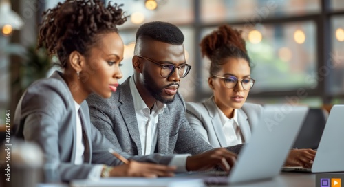 Smiling Coworkers Using Laptops
